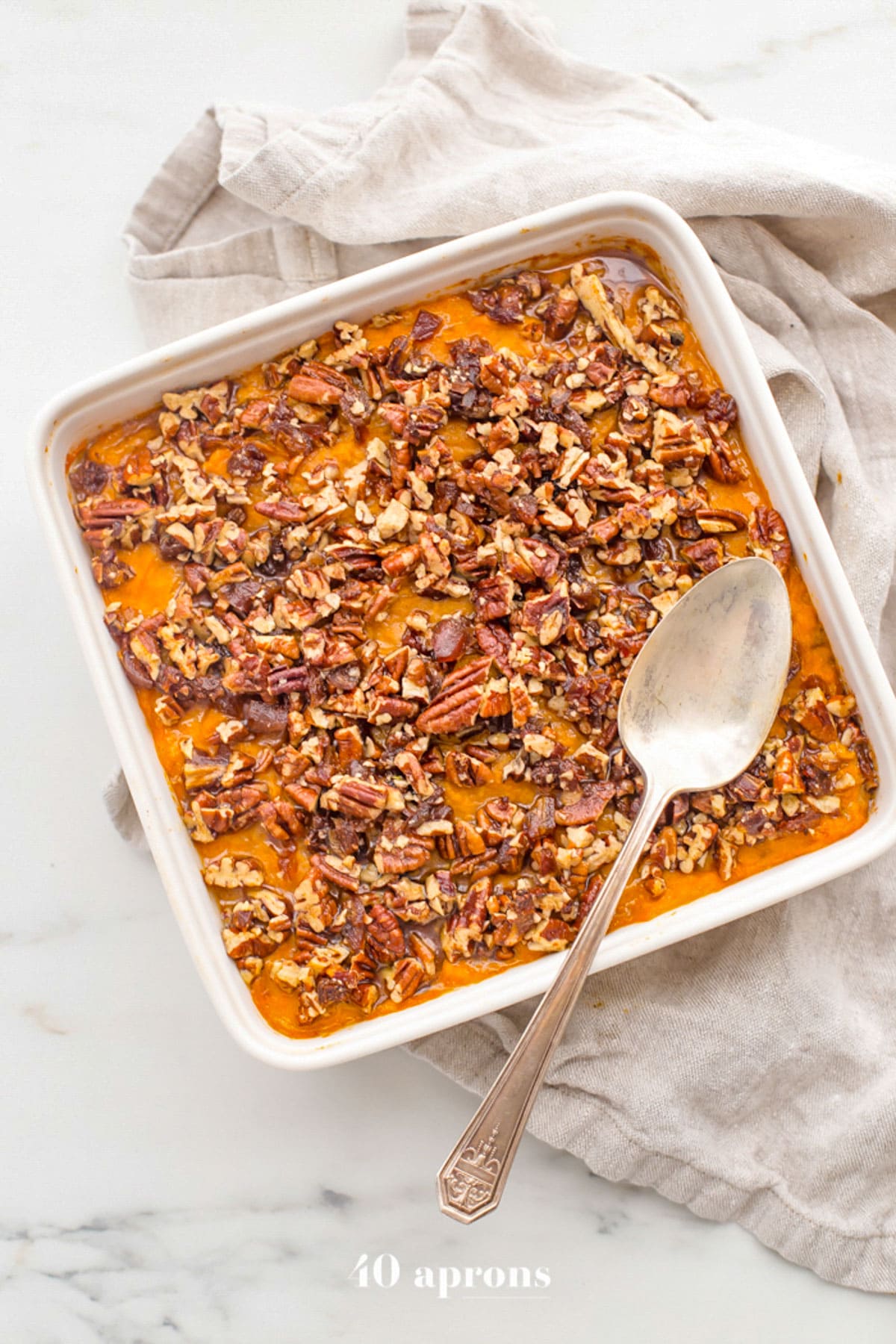 Overhead view of a square casserole dish holding a Whole30 sweet potato casserole topped with pecans.