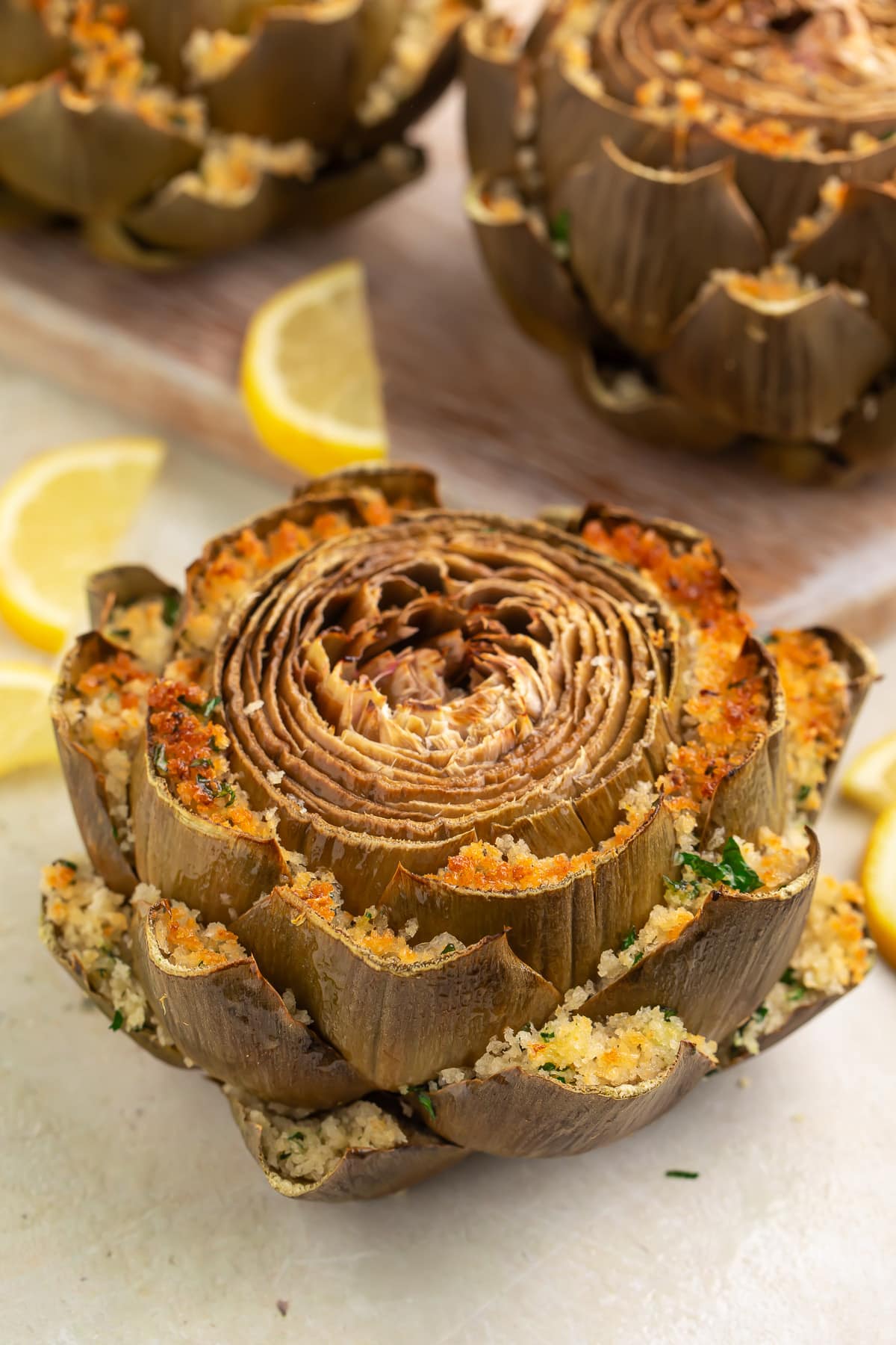 Green steamed artichokes stuffed with a baked cheese and breadcrumb mixture between each petal.