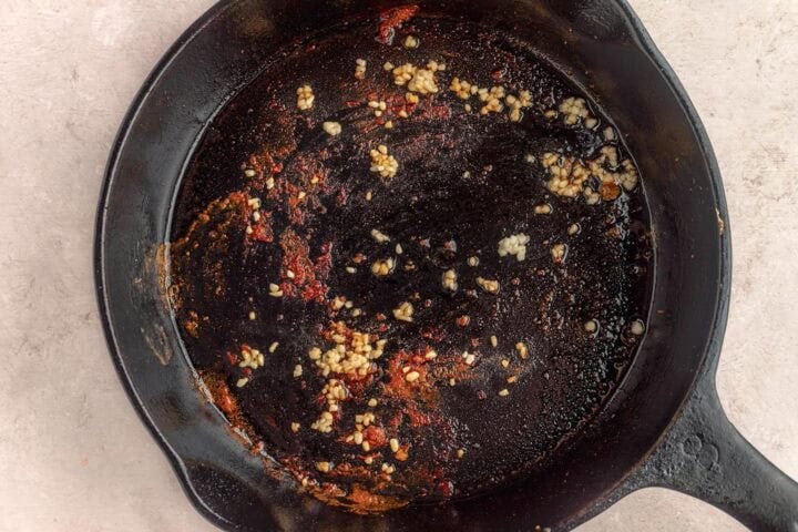 Olive oil and minced garlic in a large cast-iron skillet.