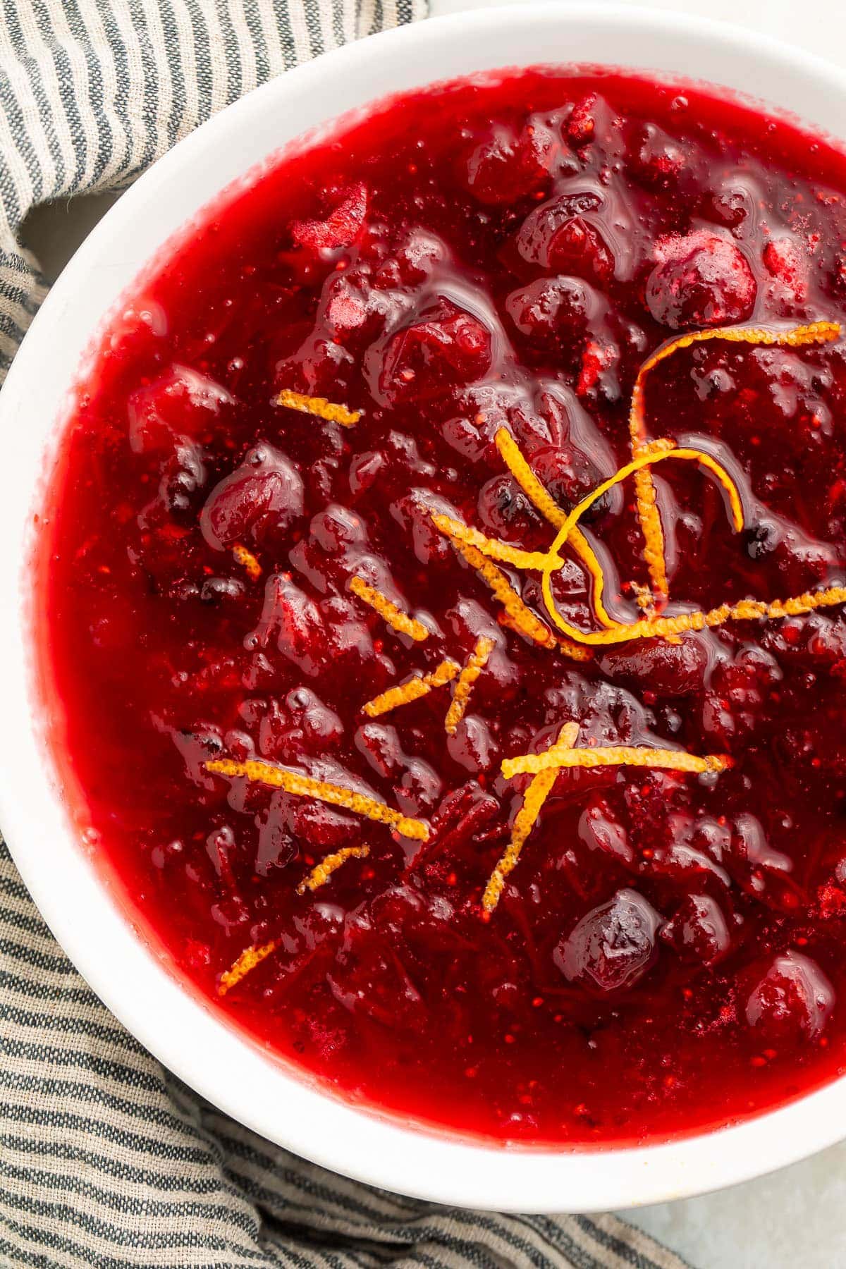 Top-down view of a large bowl of keto cranberry sauce topped with orange peel shavings.