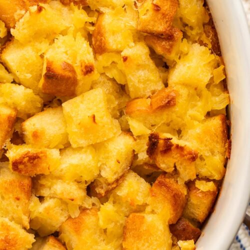 A close-up of pineapple stuffing in a large white oval ceramic baking dish.