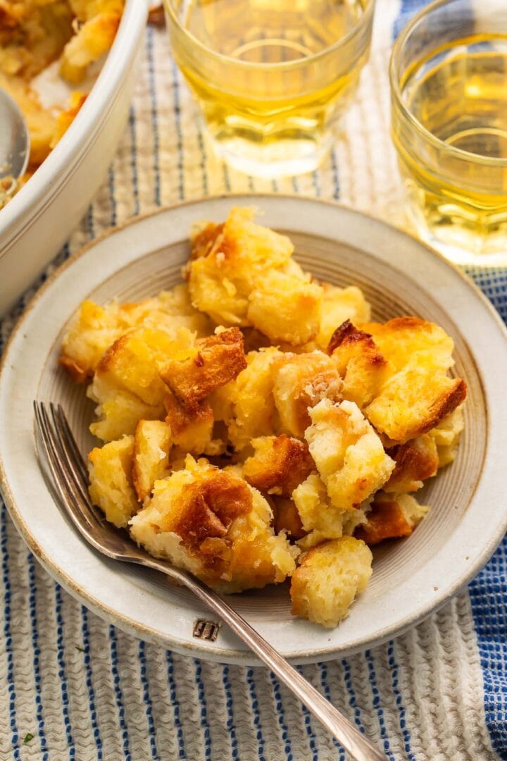 A bowl of pineapple stuffing resting on a table next to a baking dish.