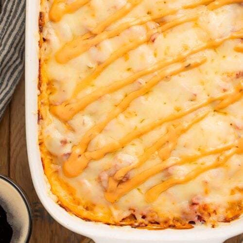 A close-up of the corner of a reuben casserole in a casserole dish.