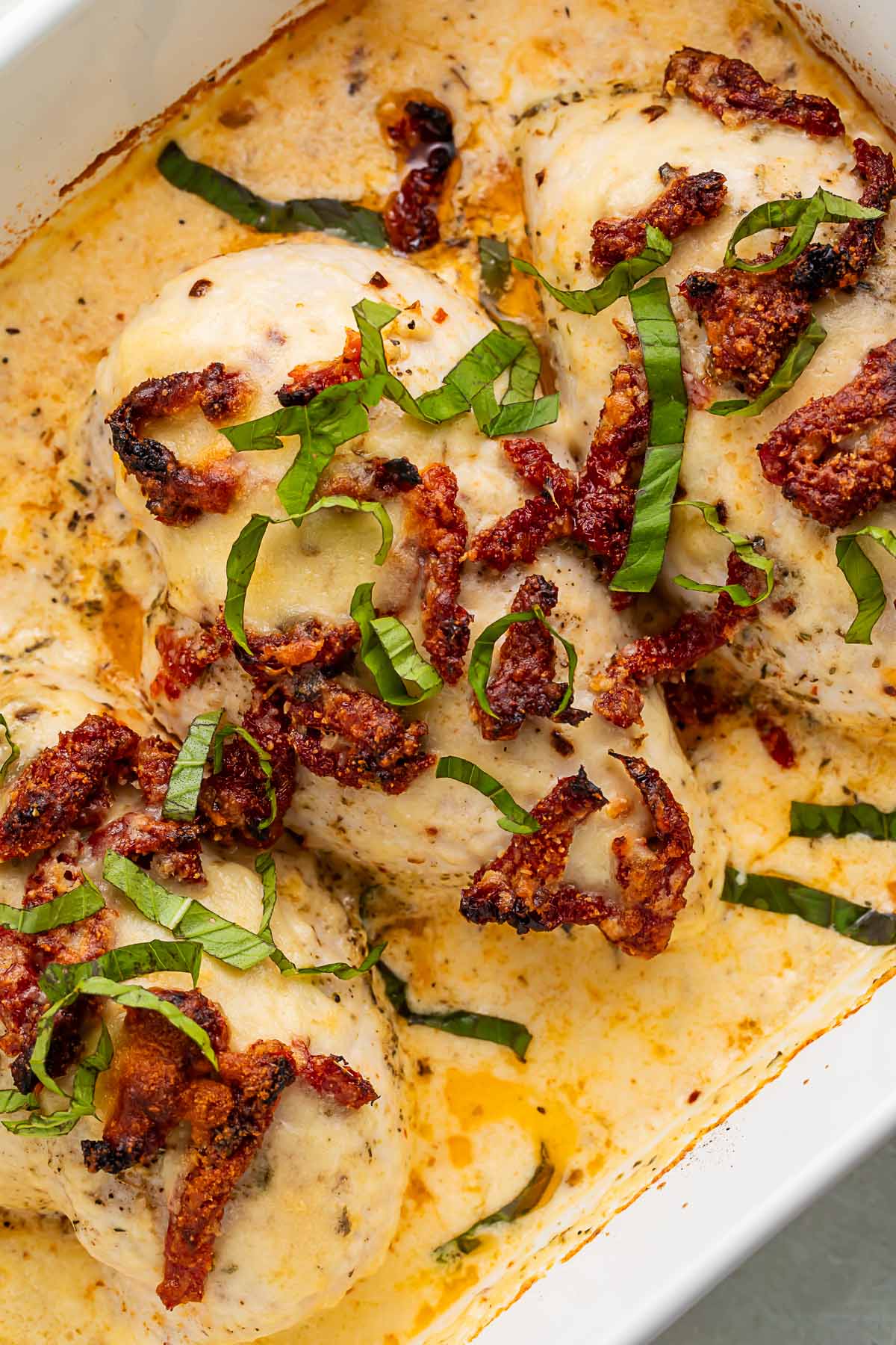 Close-up of creamy marry me chicken casserole in a casserole dish.