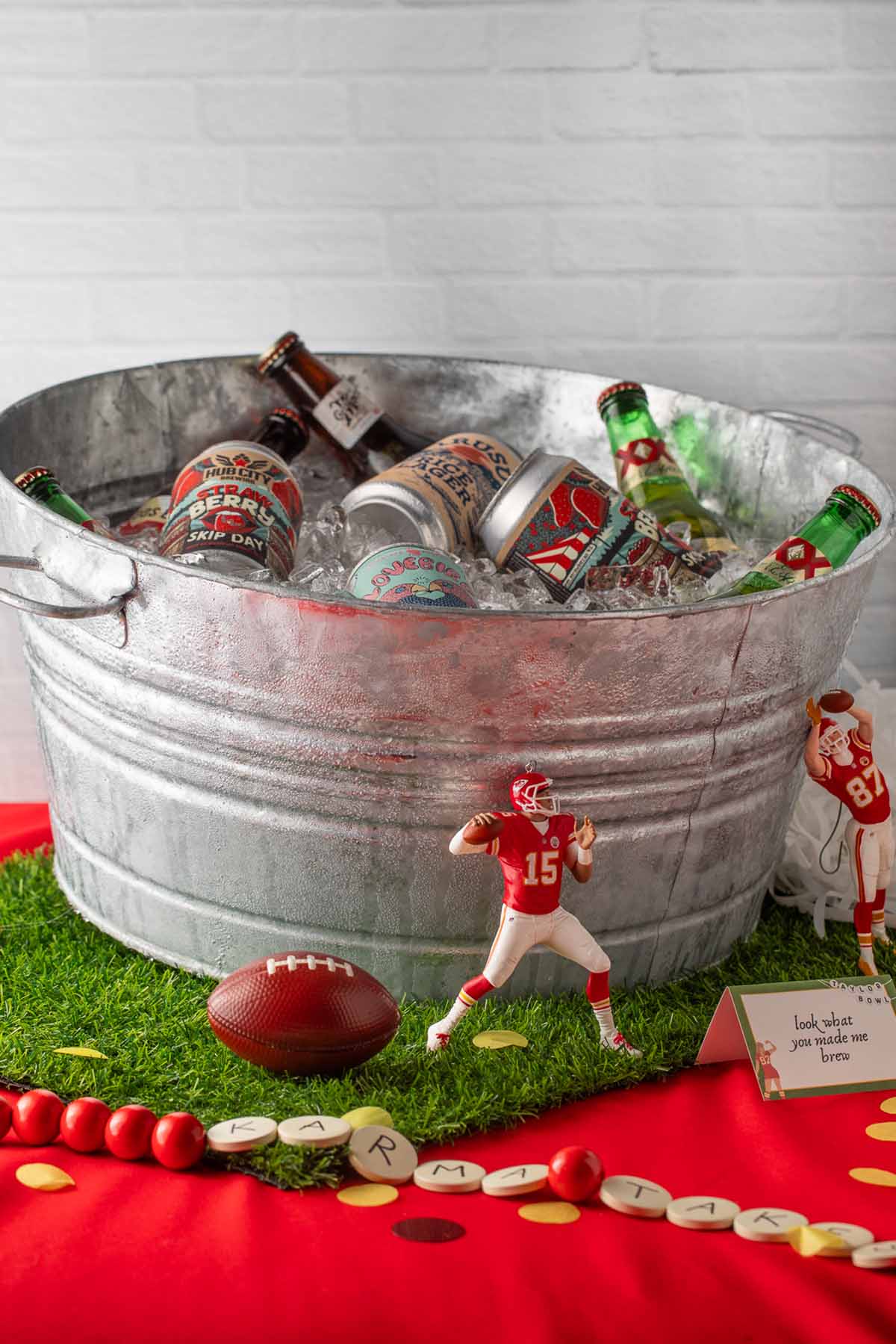 A large galvanized bucket of ice and different bottles and cans of beer.