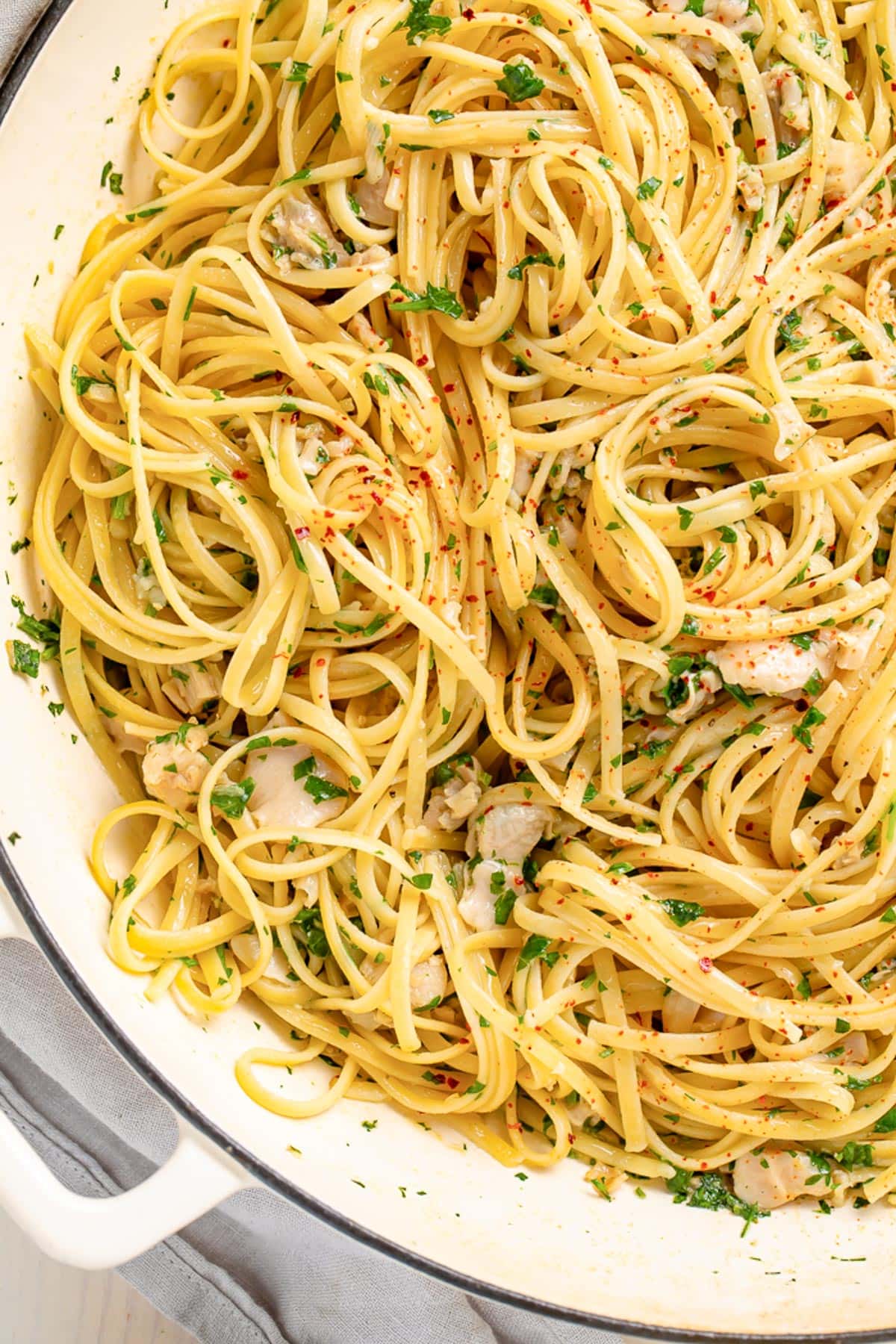 A large pot of linguine smothered in white clam sauce.