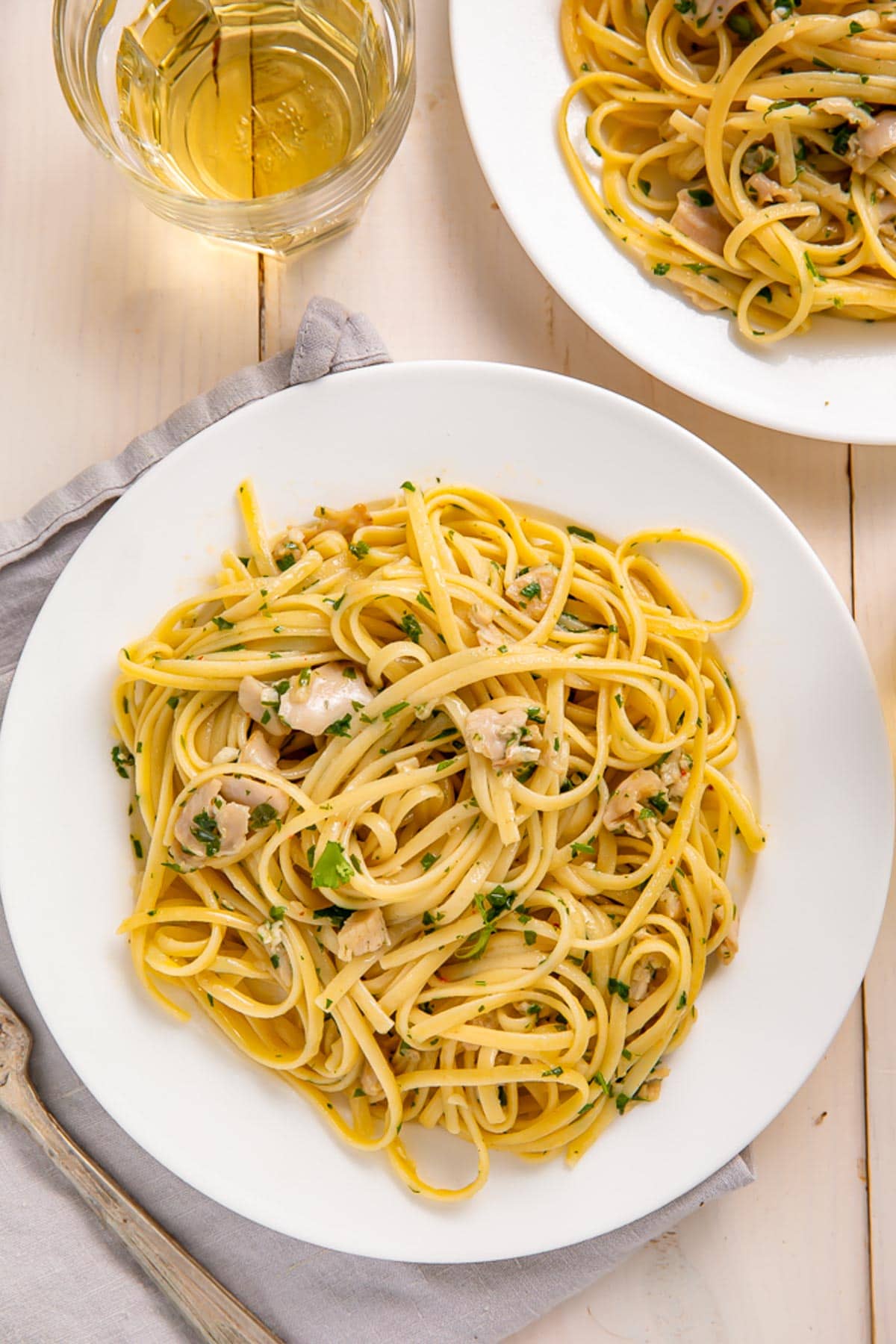 A plate of linguine tossed with white clam sauce and fresh herbs.