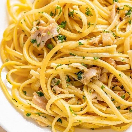 A plate of linguine tossed with white clam sauce and fresh herbs.