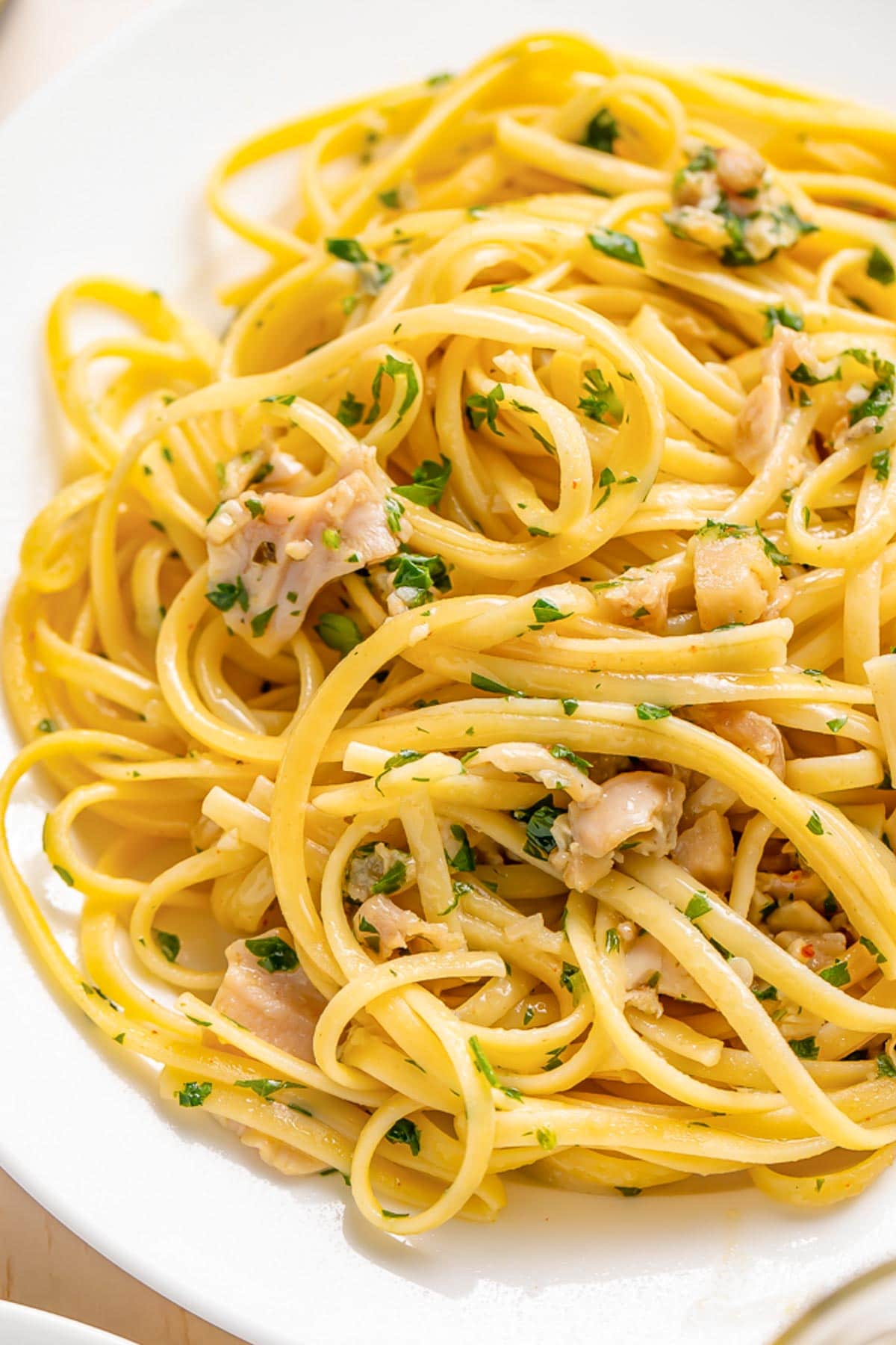 A plate of linguine tossed with white clam sauce and fresh herbs.