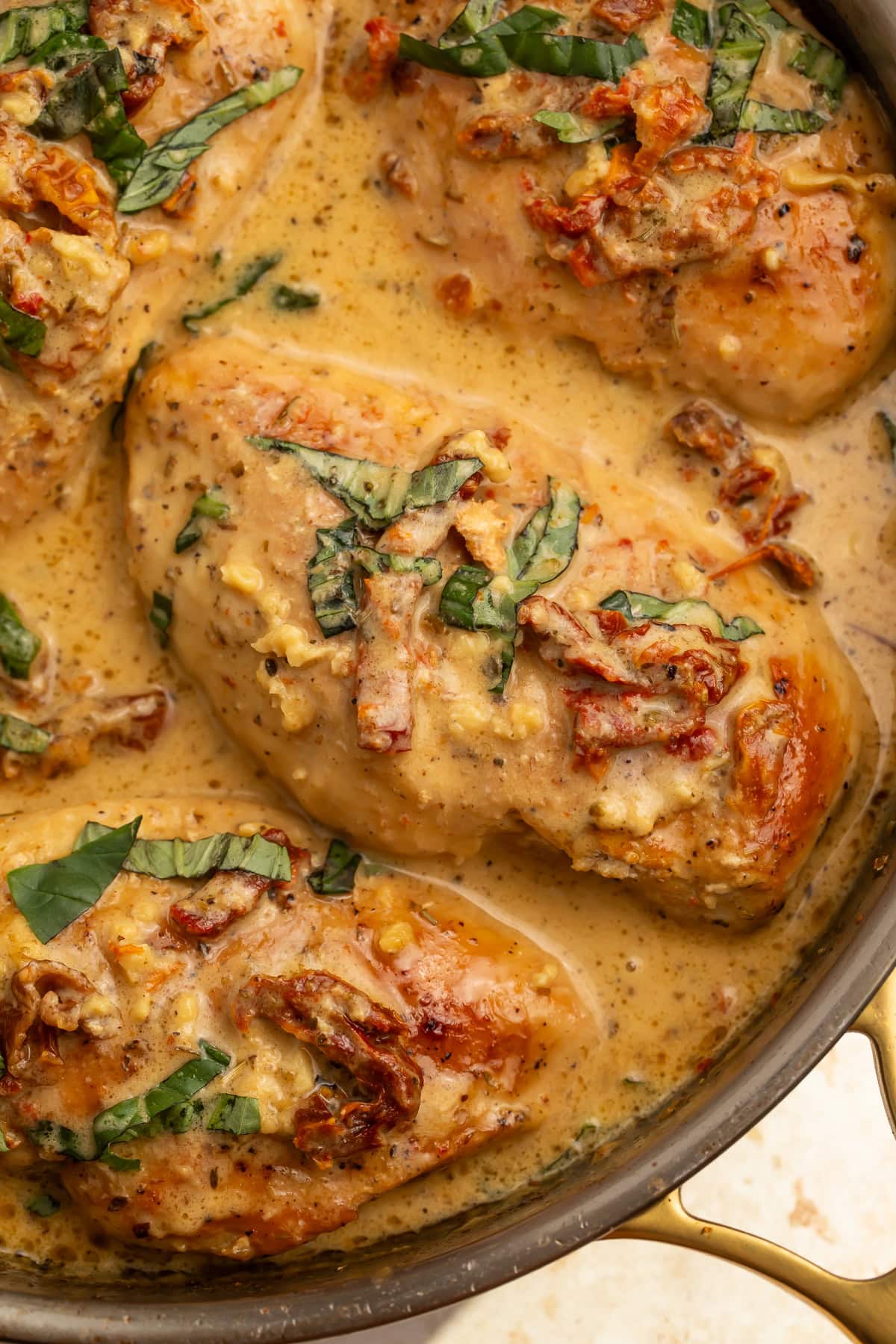 Close up of Whole30 marry me chicken breasts in skillet with creamy sauce and sun-dried tomatoes.