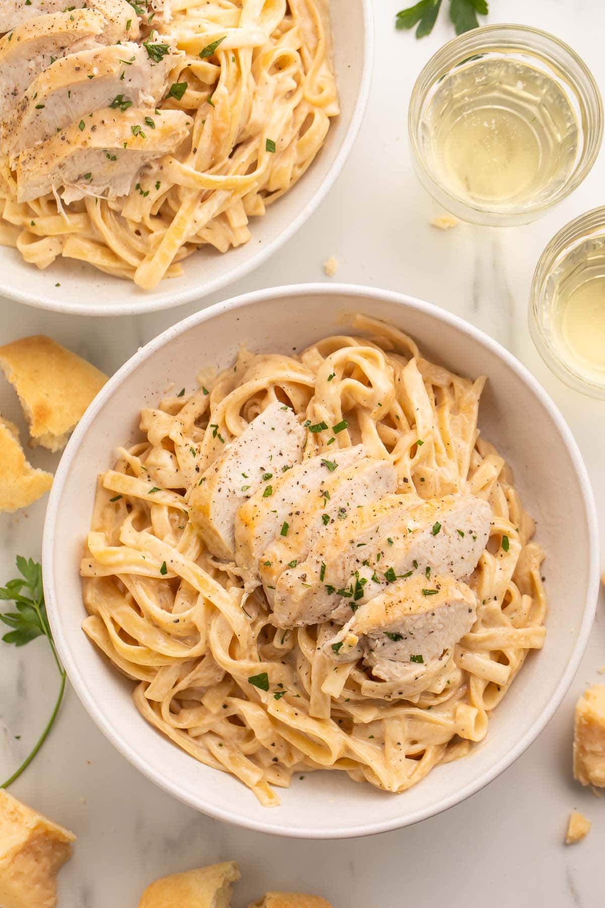 Overhead photo of a large white bowl holding chicken alfredo cooked in an Instant Pot.