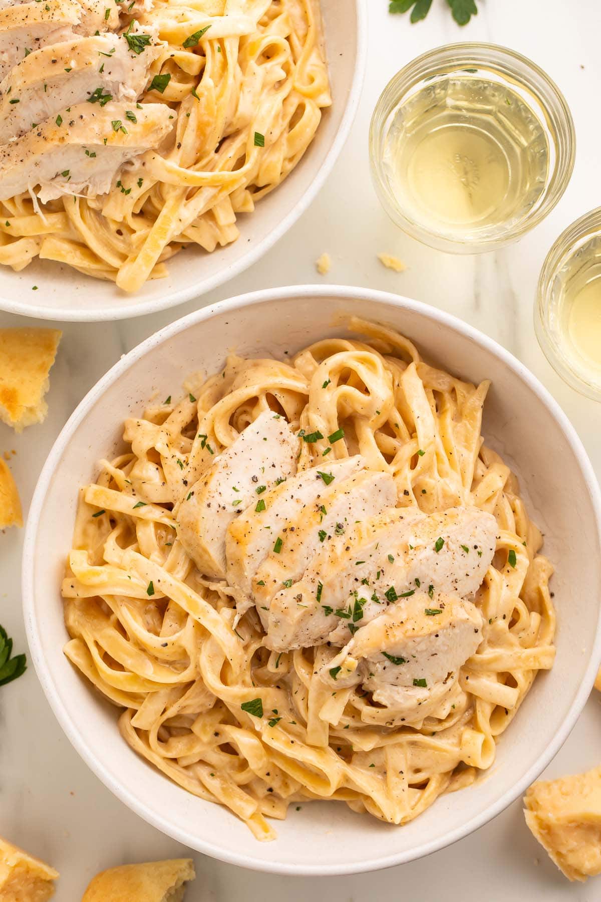 Overhead photo of a large white bowl holding chicken alfredo cooked in an Instant Pot.