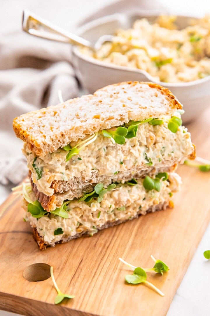 Chickpea salad sandwich on a wooden board.