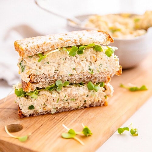 Chickpea salad sandwich on a wooden board.