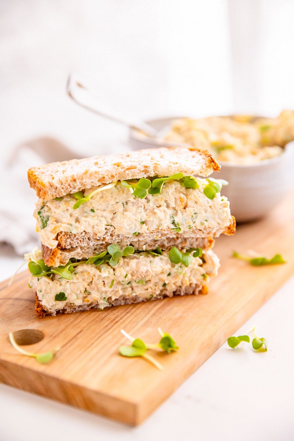 Chickpea salad sandwich on a wooden board.