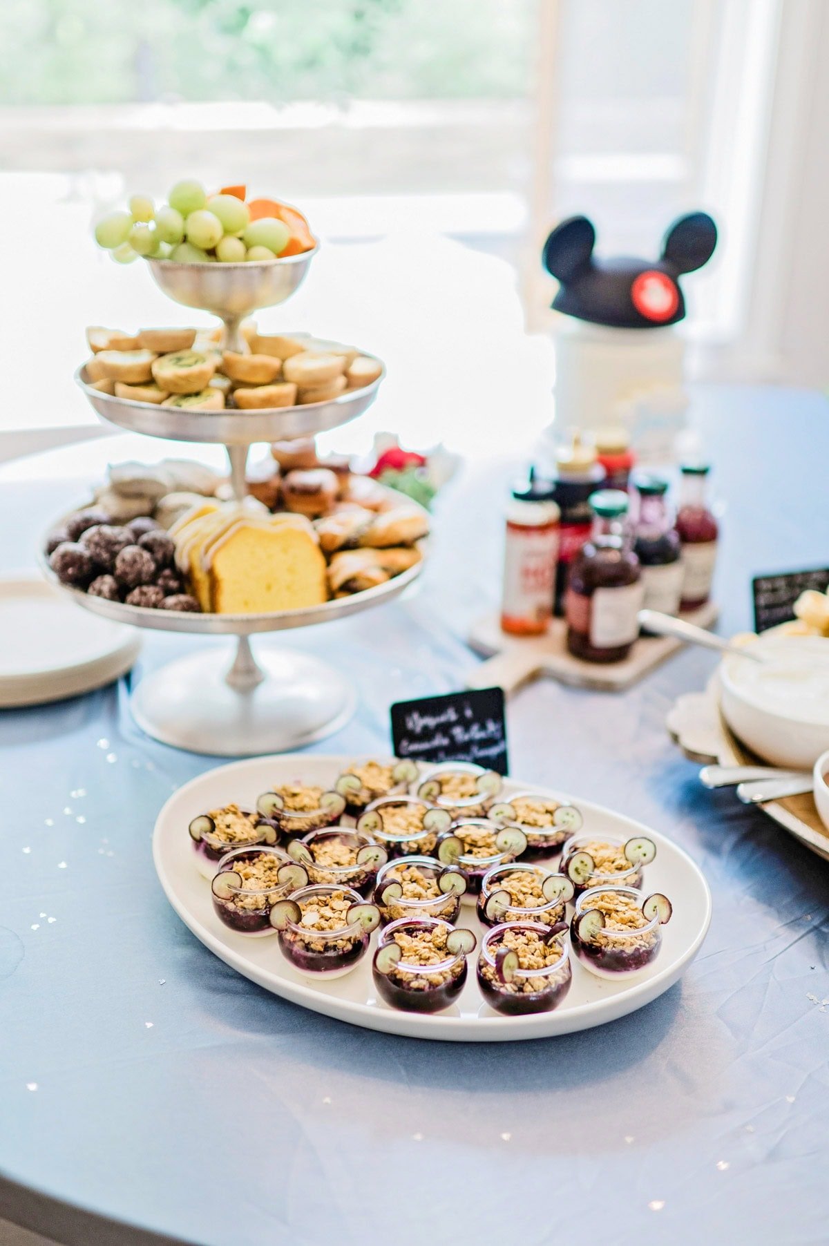 Brunch foods on platters and tiered trays for a Magic Kingdom birthday party.