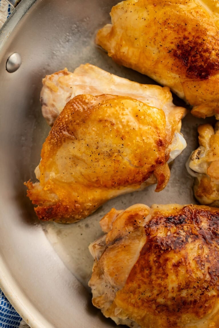 Perfect crispy chicken thighs in a large skillet.