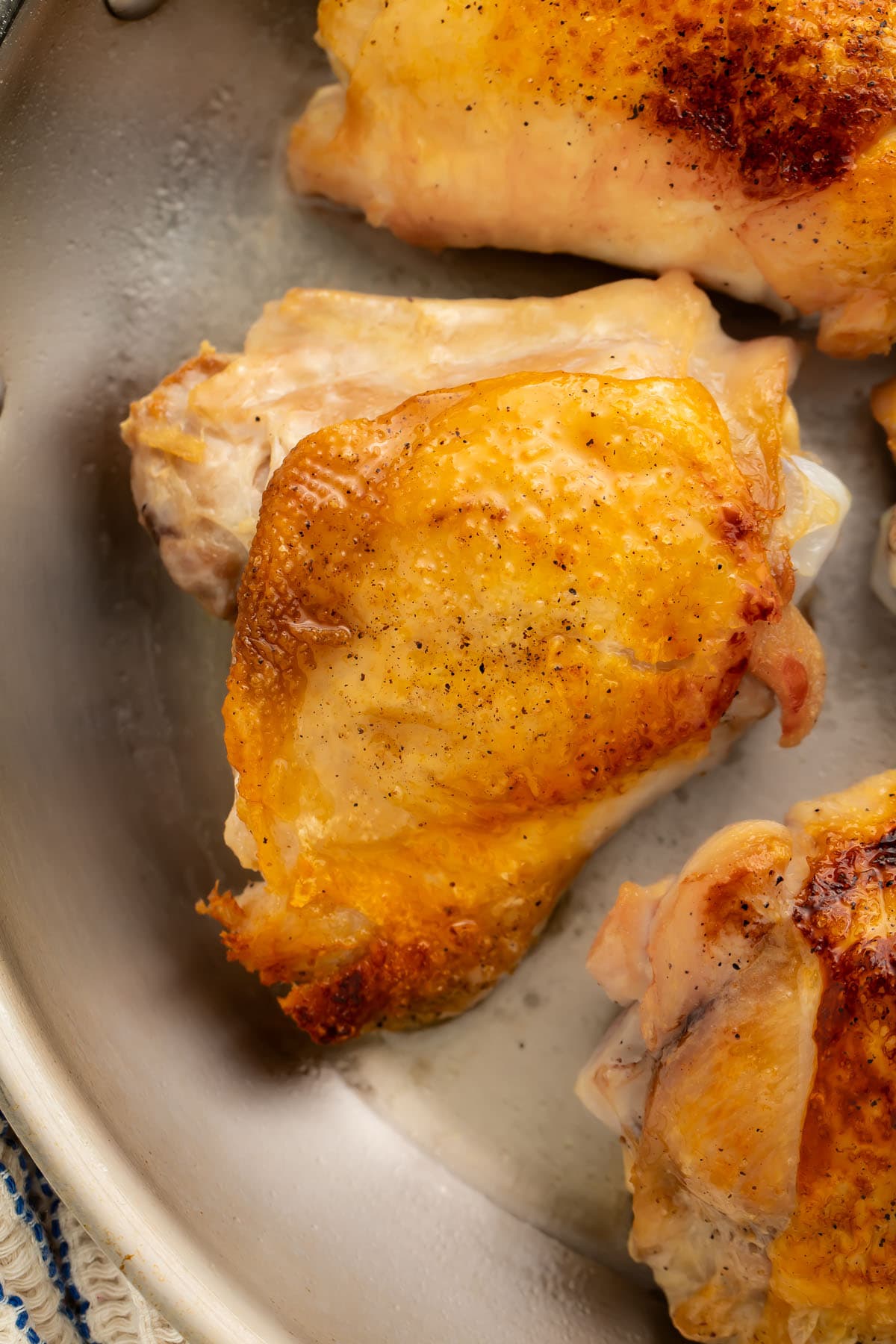 Perfect crispy chicken thighs in a large skillet.
