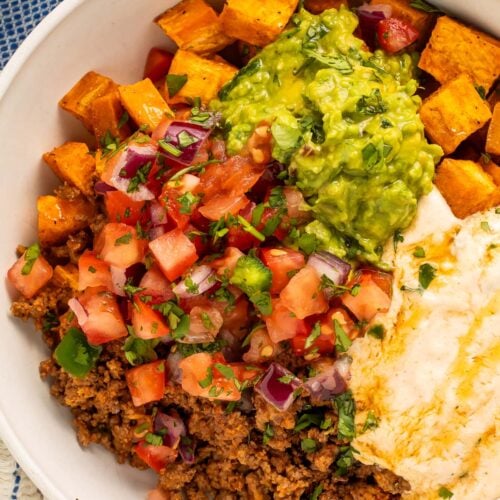 Close-up photo of a Southwest Ground Beef Bowl with Cottage Cheese Queso on a table.