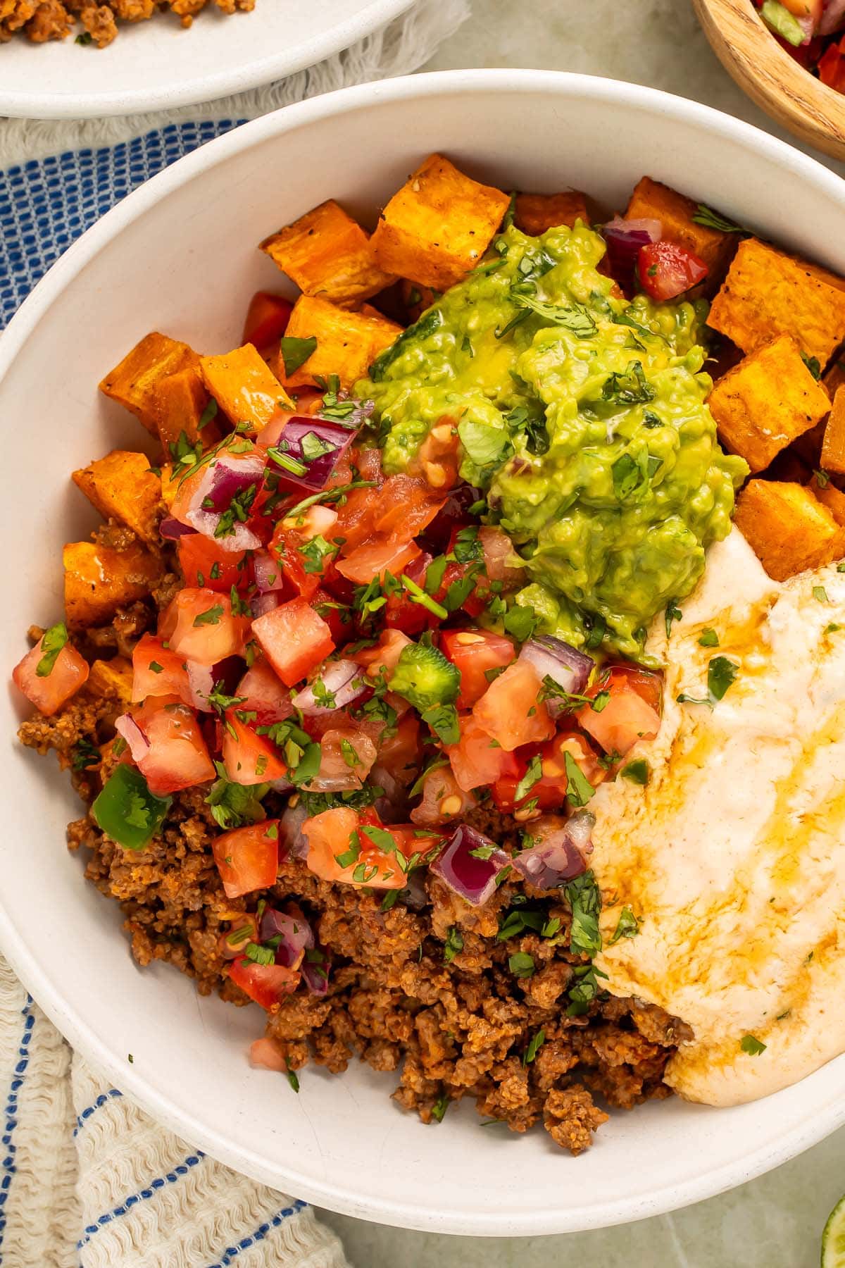 Close-up photo of a Southwest Ground Beef Bowl with Cottage Cheese Queso on a table.