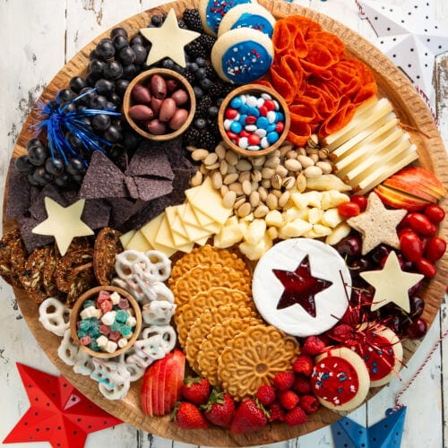 Overhead photo of a 4th of July, red-white-and-blue themed charcuterie board on a table.