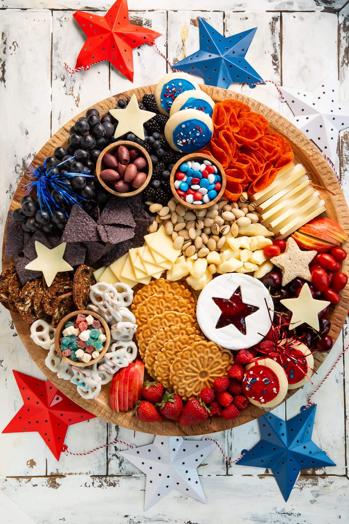 Overhead photo of a 4th of July, red-white-and-blue themed charcuterie board on a table.
