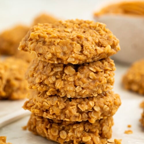 Stack of no bake peanut butter oatmeal cookies on a piece of wax paper.