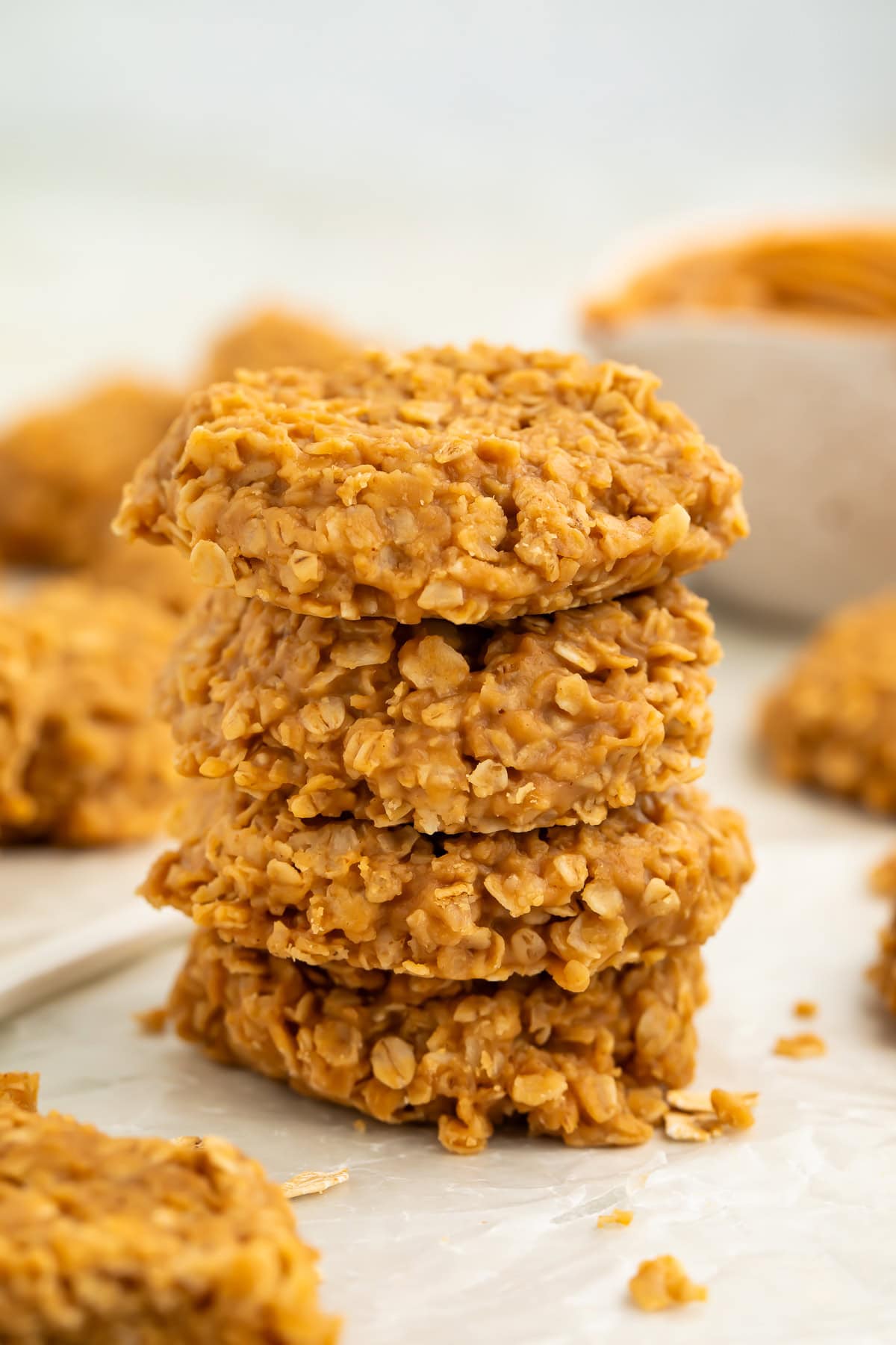 Stack of no bake peanut butter oatmeal cookies on a piece of wax paper.