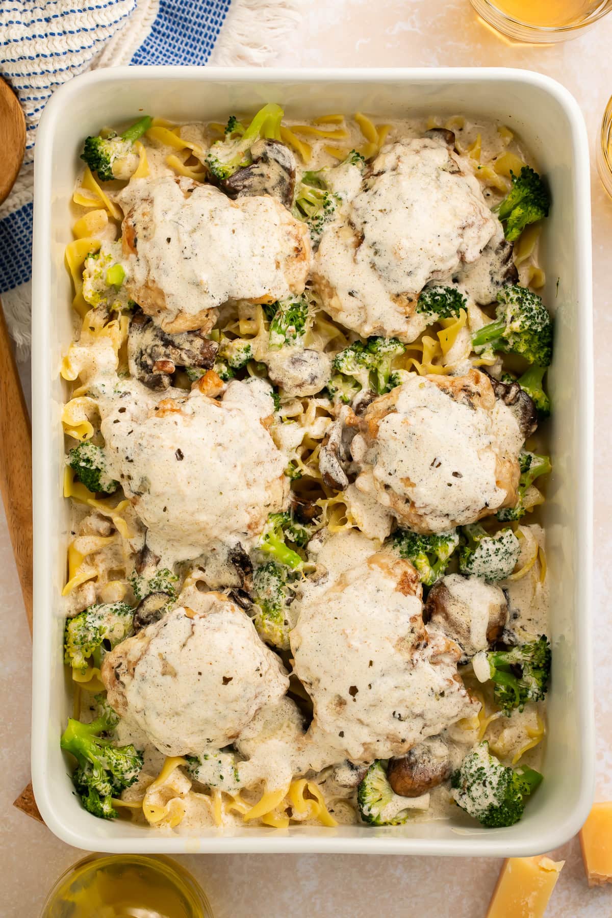 Chicken divan casserole in white baking dish with golden-brown broiled top and fresh broccoli