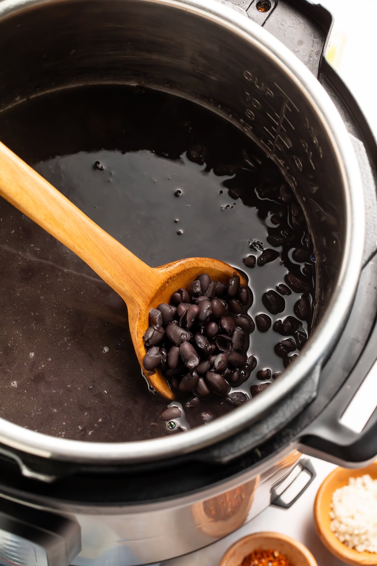 Overhead view of seasoned black beans in instant pot with spices