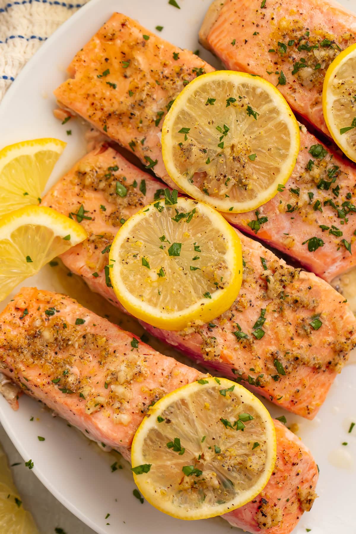 Baked salmon fillet being cut with fork showing flaky interior