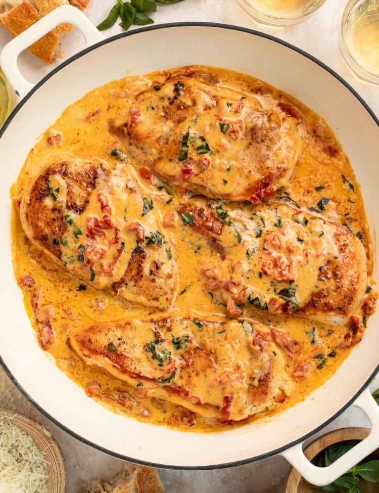 "Tender chicken breasts covered in rich cream sauce with herbs and tomatoes