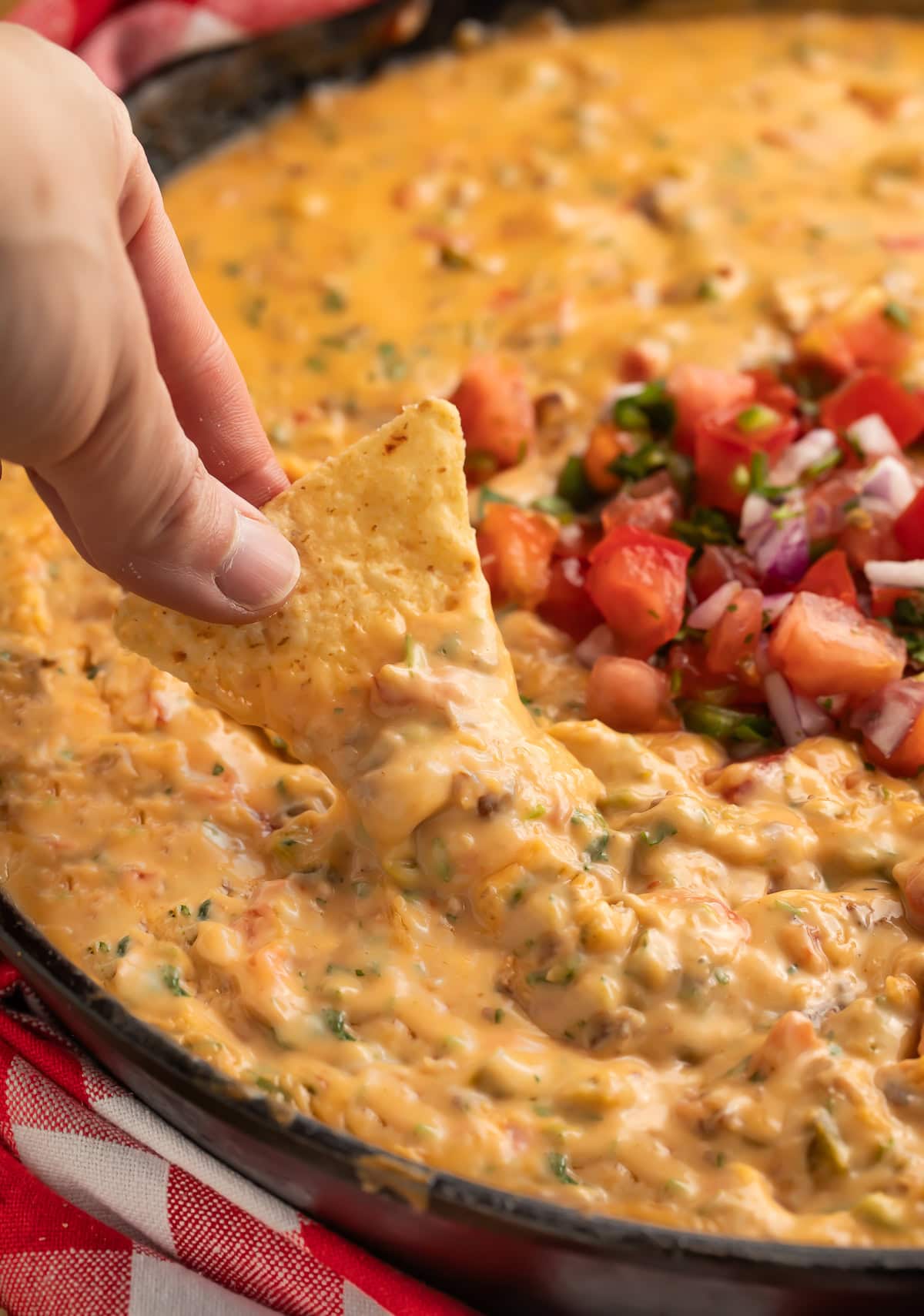 Smoked queso dip served with tortilla chips, garnished with cilantro.