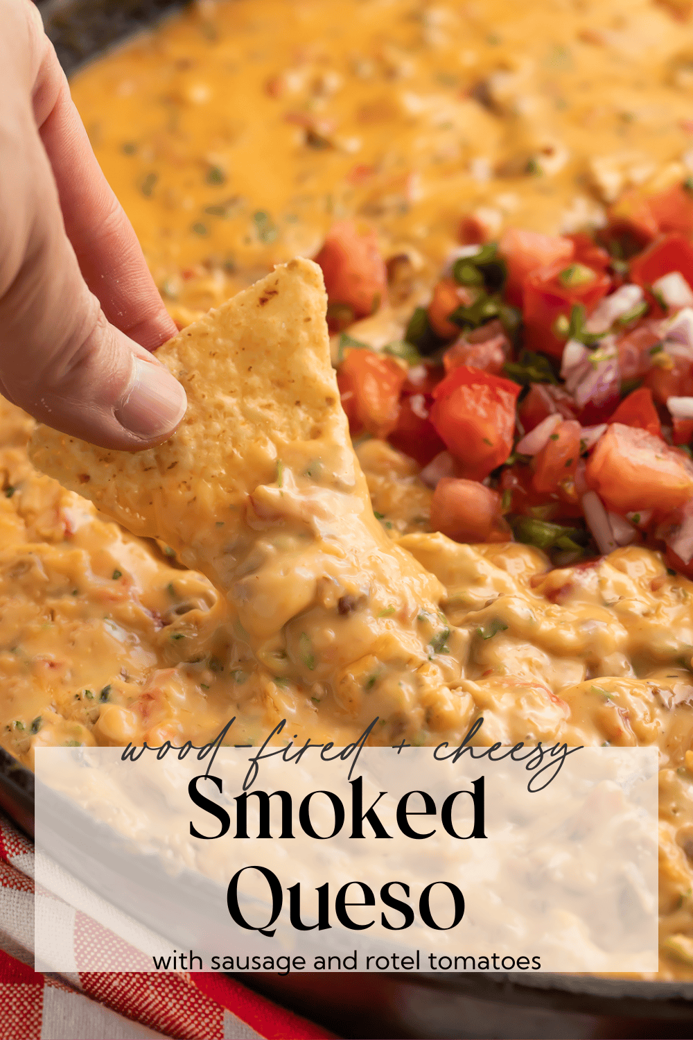 Creamy smoked queso dip with melted cheese and sausage in a cast iron skillet, garnished with fresh cilantro.