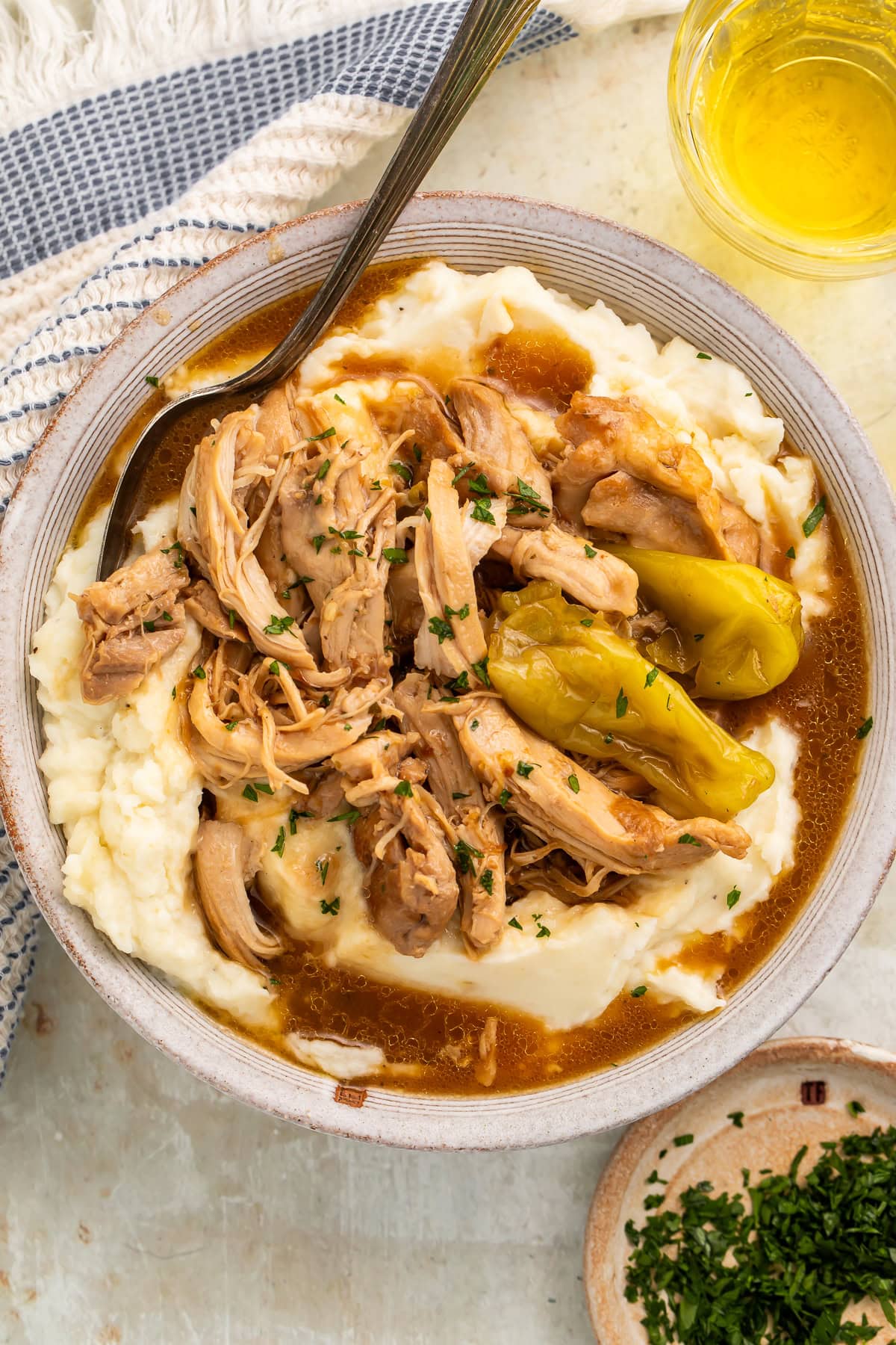 Mississippi chicken pot roast served over creamy mashed potatoes with rich gravy and pepperoncini peppers garnished with fresh parsley
