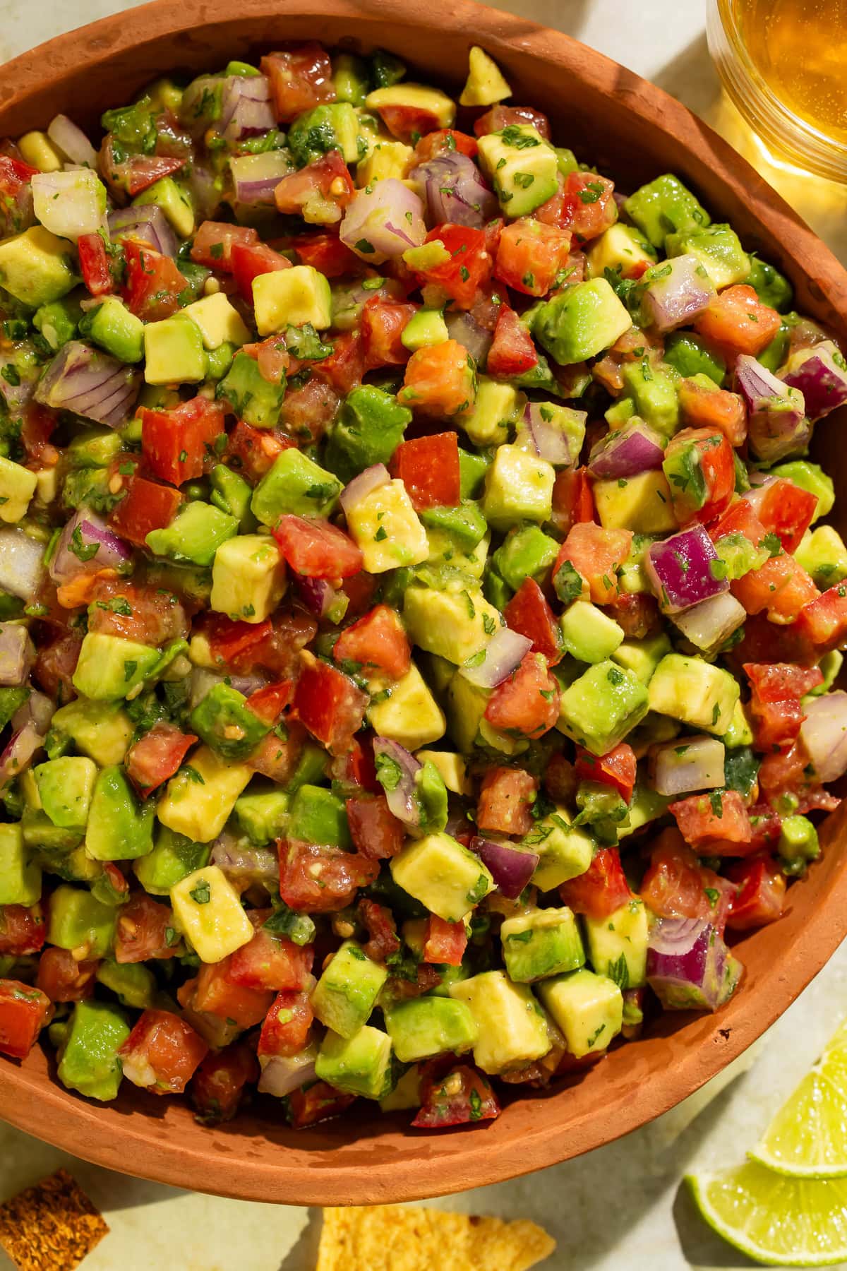Avocado tomato salsa in wooden bowl showing chunky texture and fresh ingredients