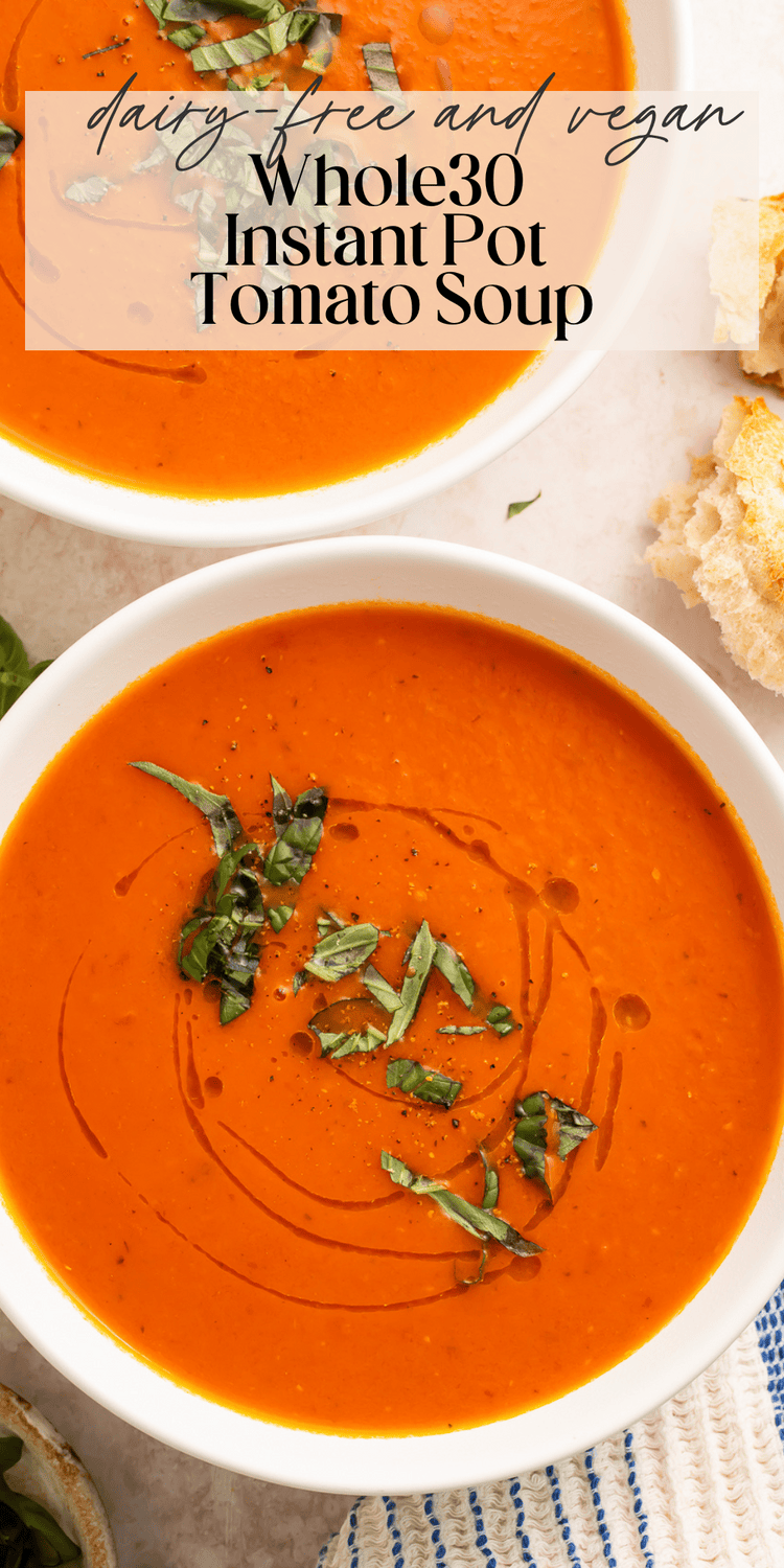 Two bowls of creamy Whole30 tomato soup served with crusty bread and fresh