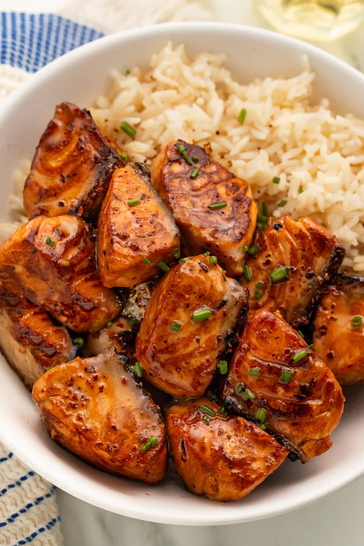 Close-up of hot honey glazed salmon bites with sesame seeds and green onions