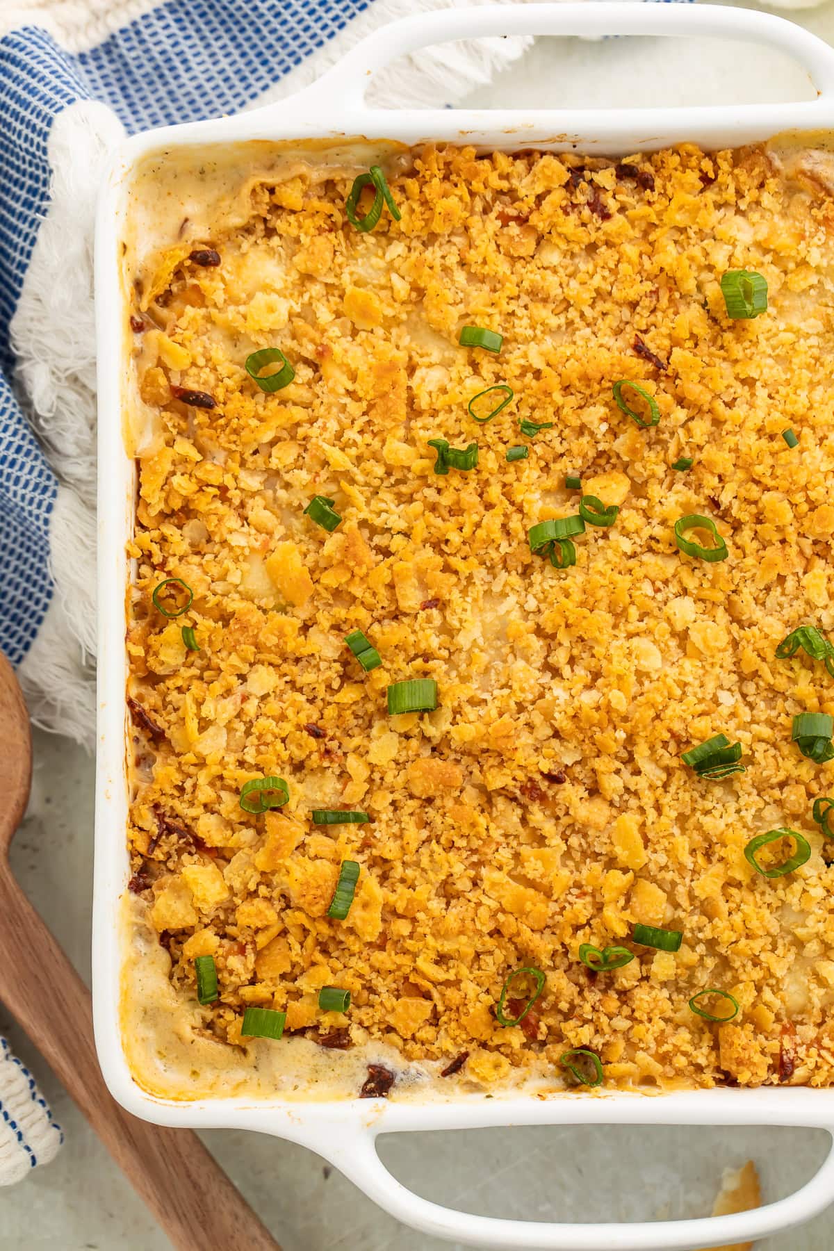 Million Dollar Chicken Casserole with golden cracker topping and fresh scallions in white baking dish