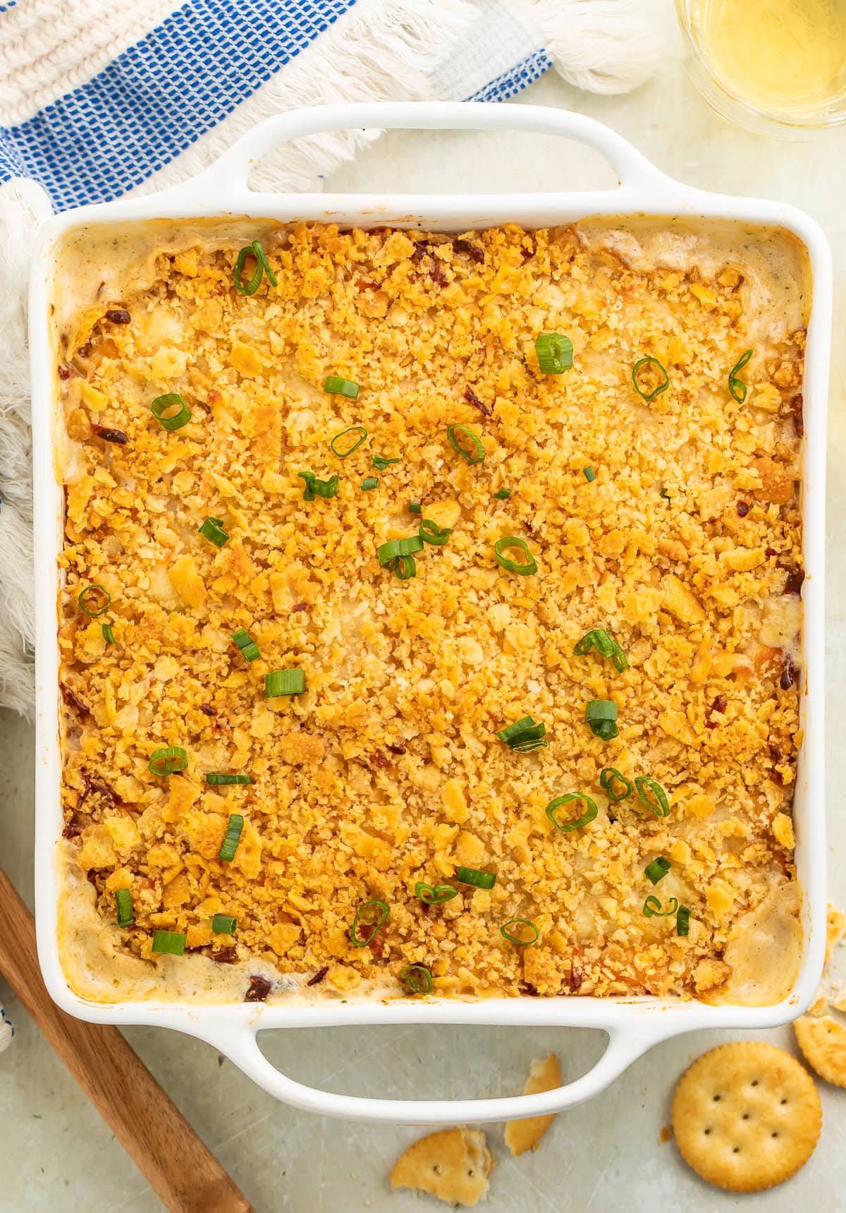 Complete Million Dollar Chicken Casserole in white baking dish with crackers scattered around