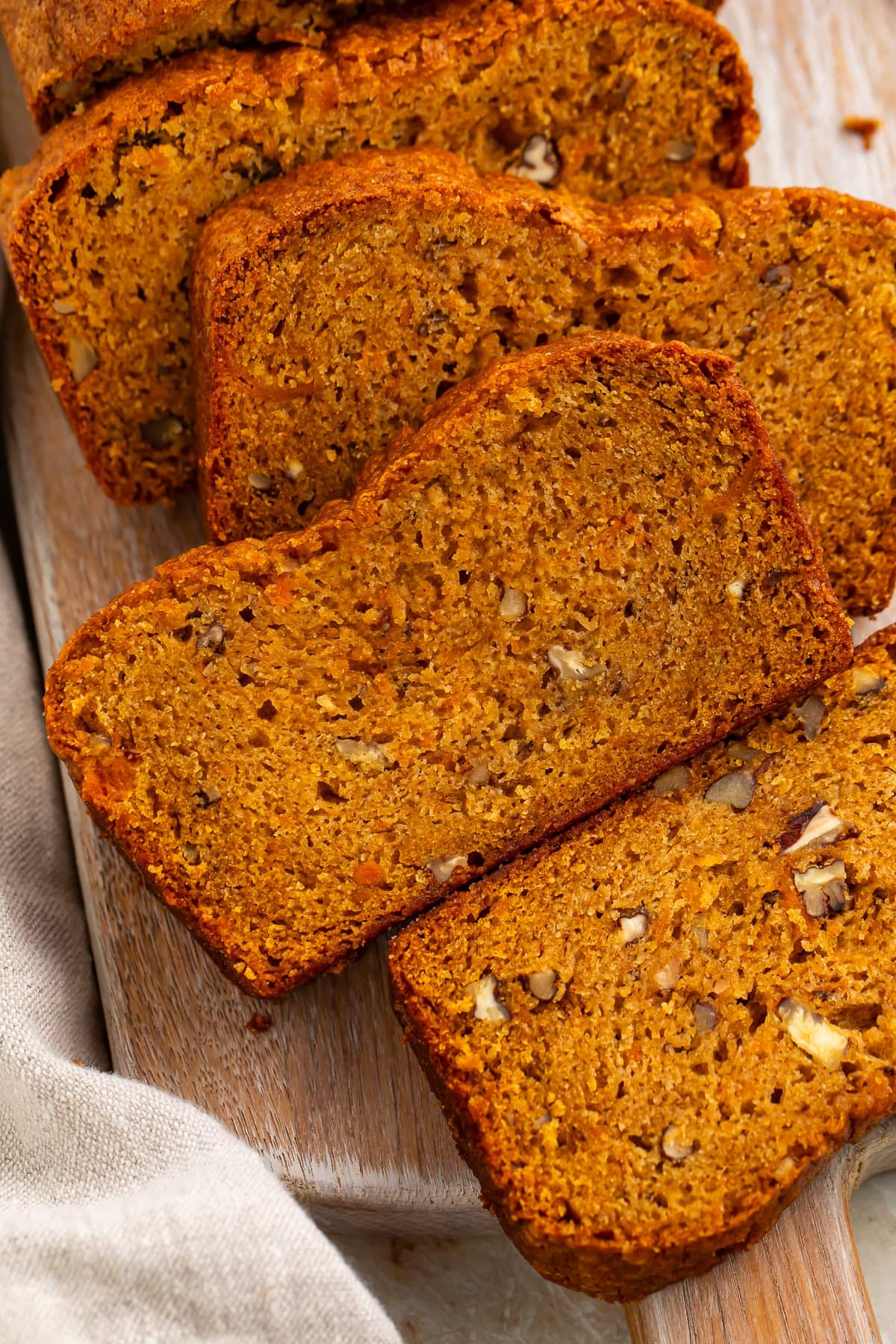 Close-up of sweet potato bread slices showing dense moist texture and pecan pieces 