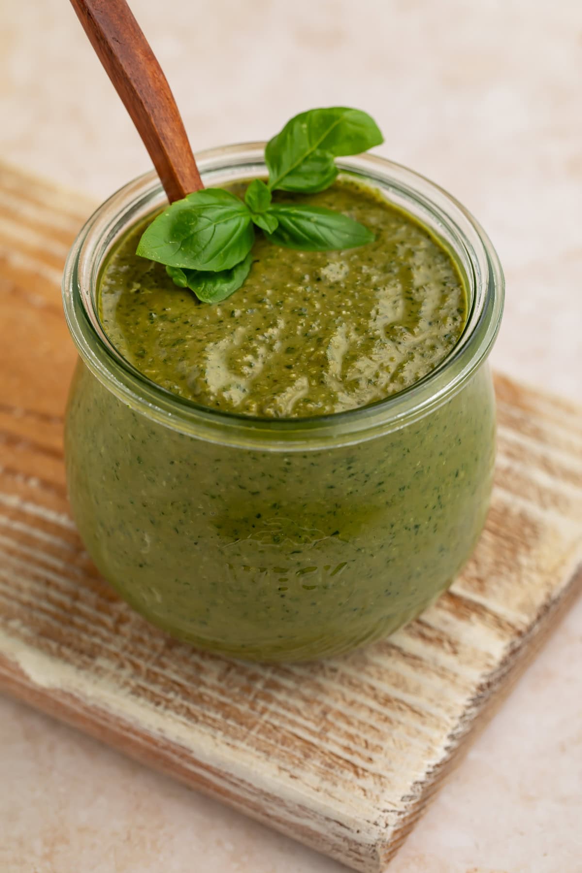 Close-up view of creamy pesto sauce showing texture in glass jar