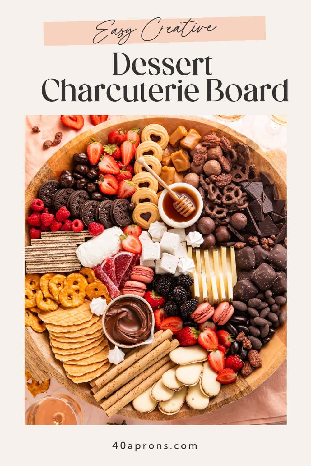 Dessert charcuterie board ideas showing chocolate dip Nutella fresh strawberries raspberries cookies macarons and cheese arranged on wooden platter.