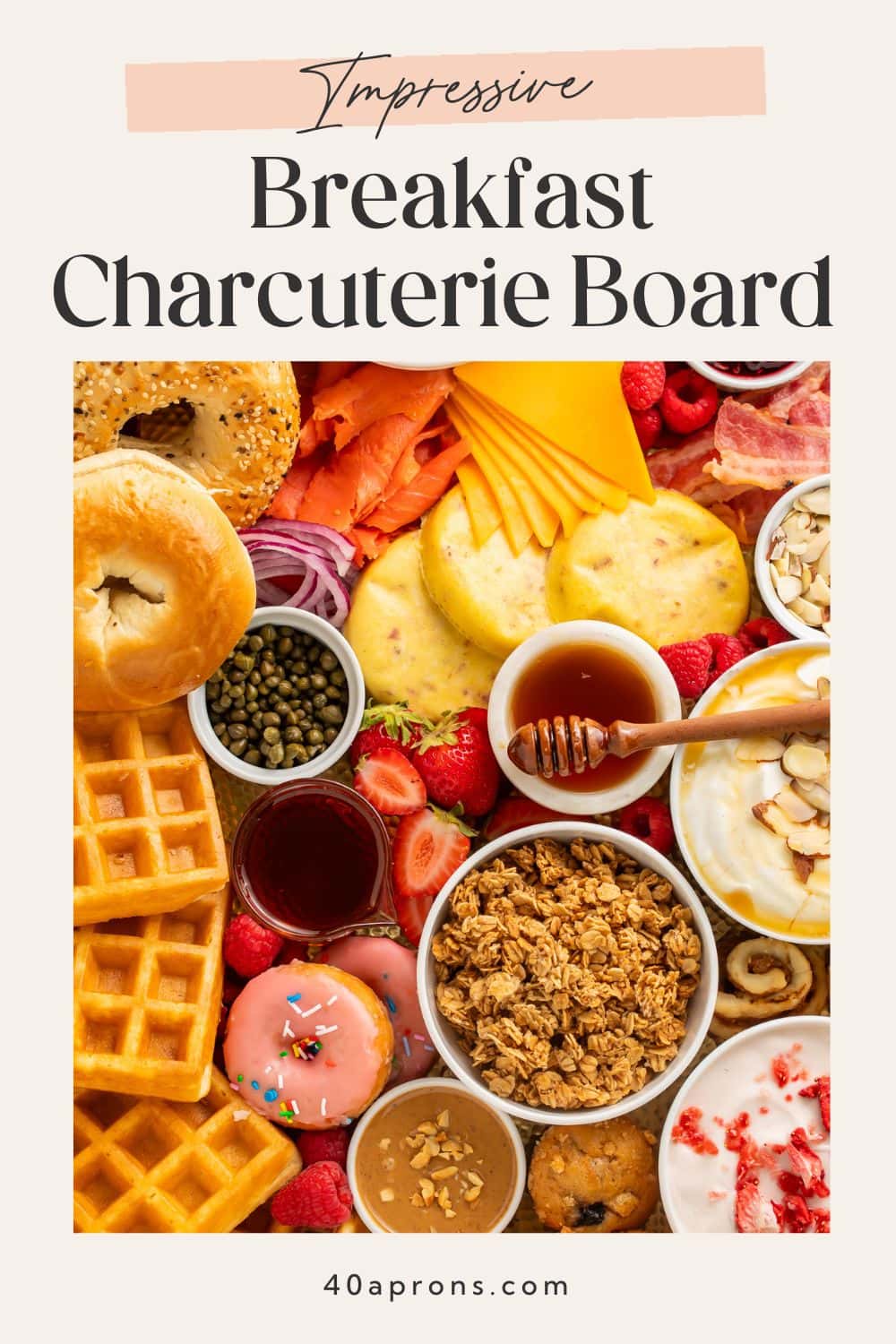 Pinterest pin showing full breakfast charcuterie board with bagels, waffles, croissants, yogurt, and fruit with text overlay "Impressive Breakfast Charcuterie Board" and 40aprons.com.