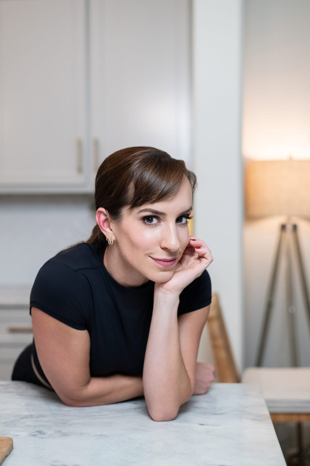 Portrait of a woman leaning on a kitchen counter, featured as part of a Black Friday gift guide.