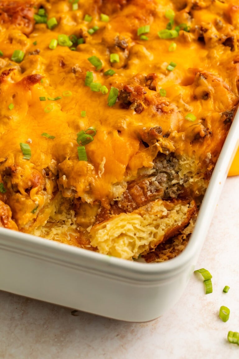 Close-up overhead view of croissant breakfast casserole showing layers of custard, sausage, and cheese