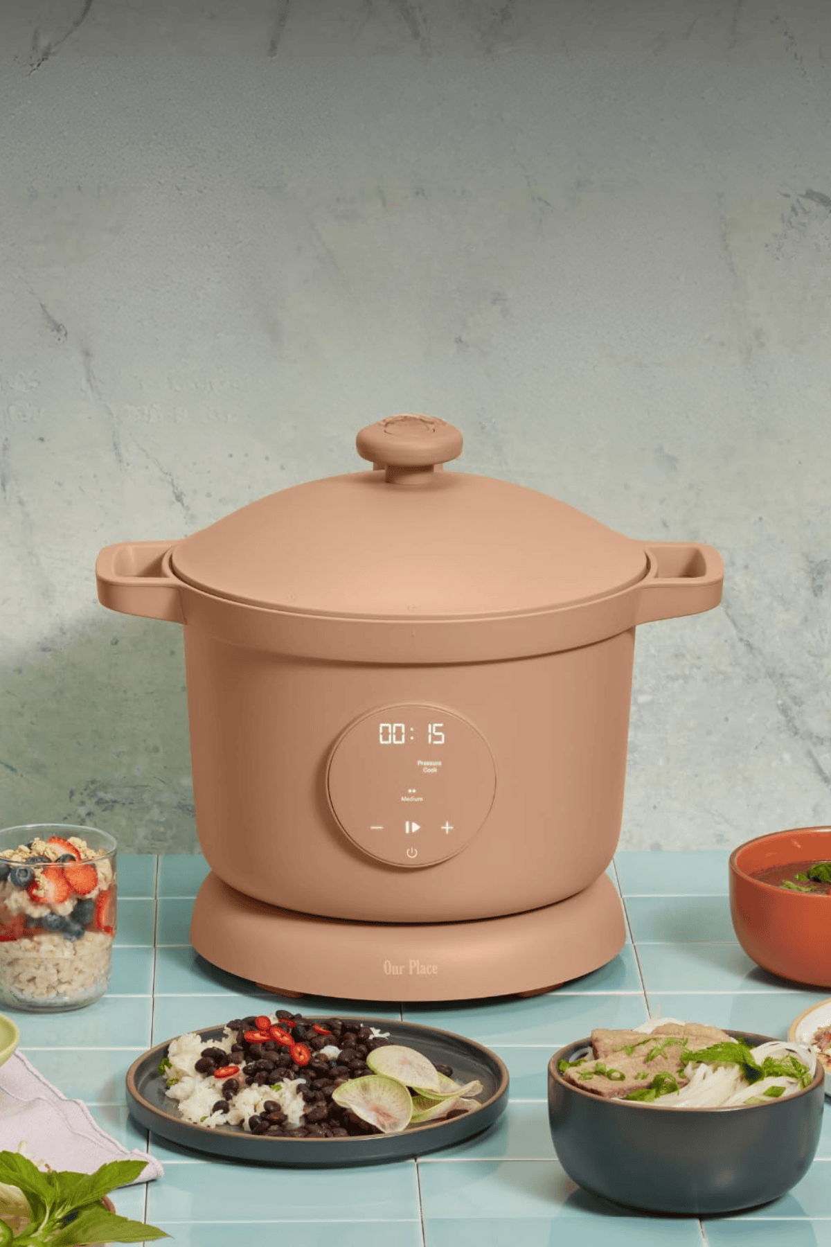 Our Place Dream Cooker pressure cooker in coral color with digital display on counter