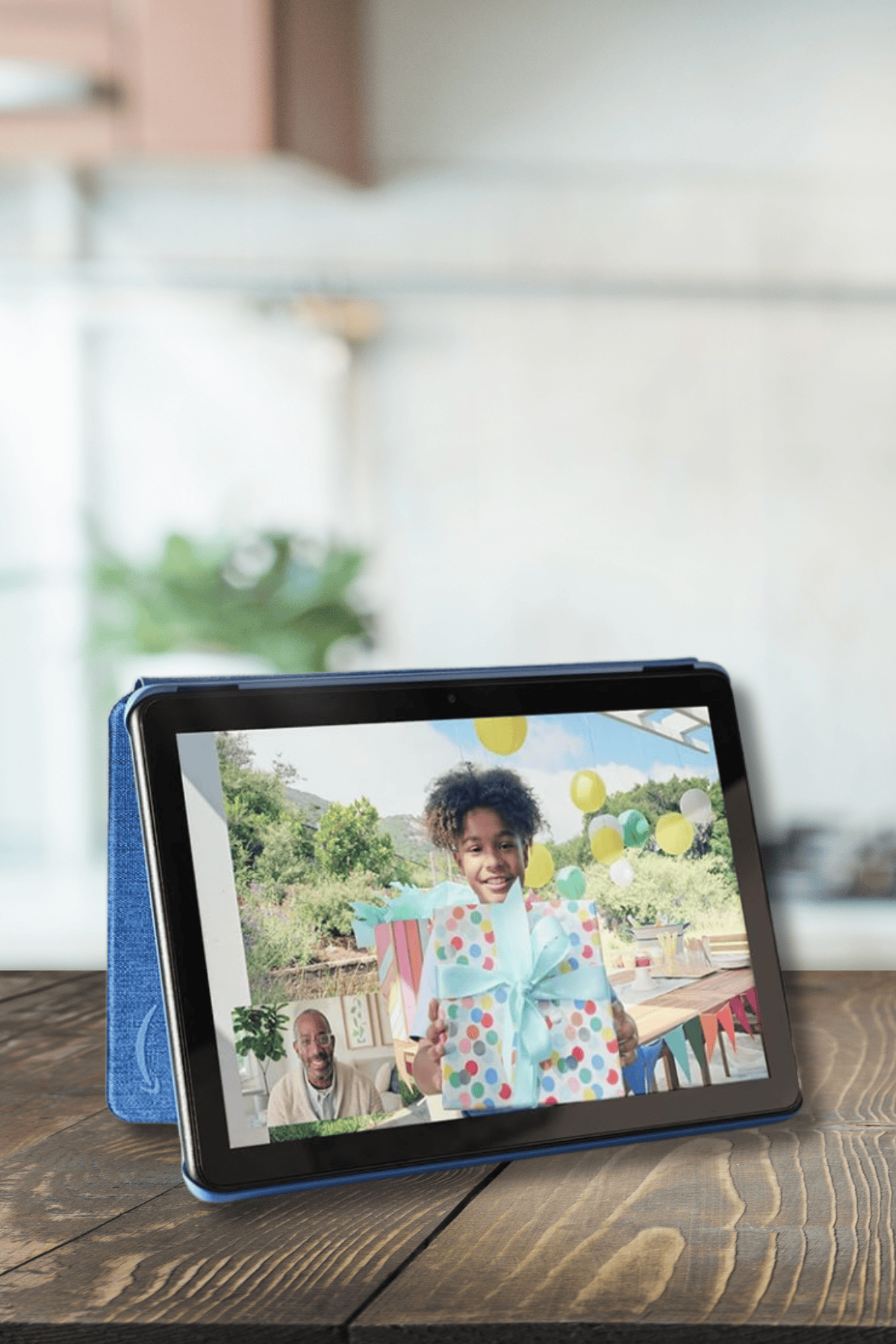Amazon Fire HD 10 tablet in blue case showing video call with child at birthday party