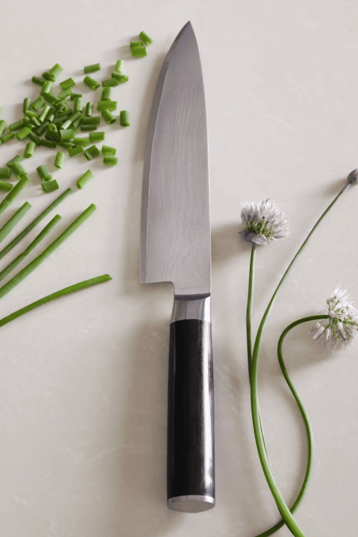 Quince Japanese Damascus steel chef knife with chopped chives and flowers