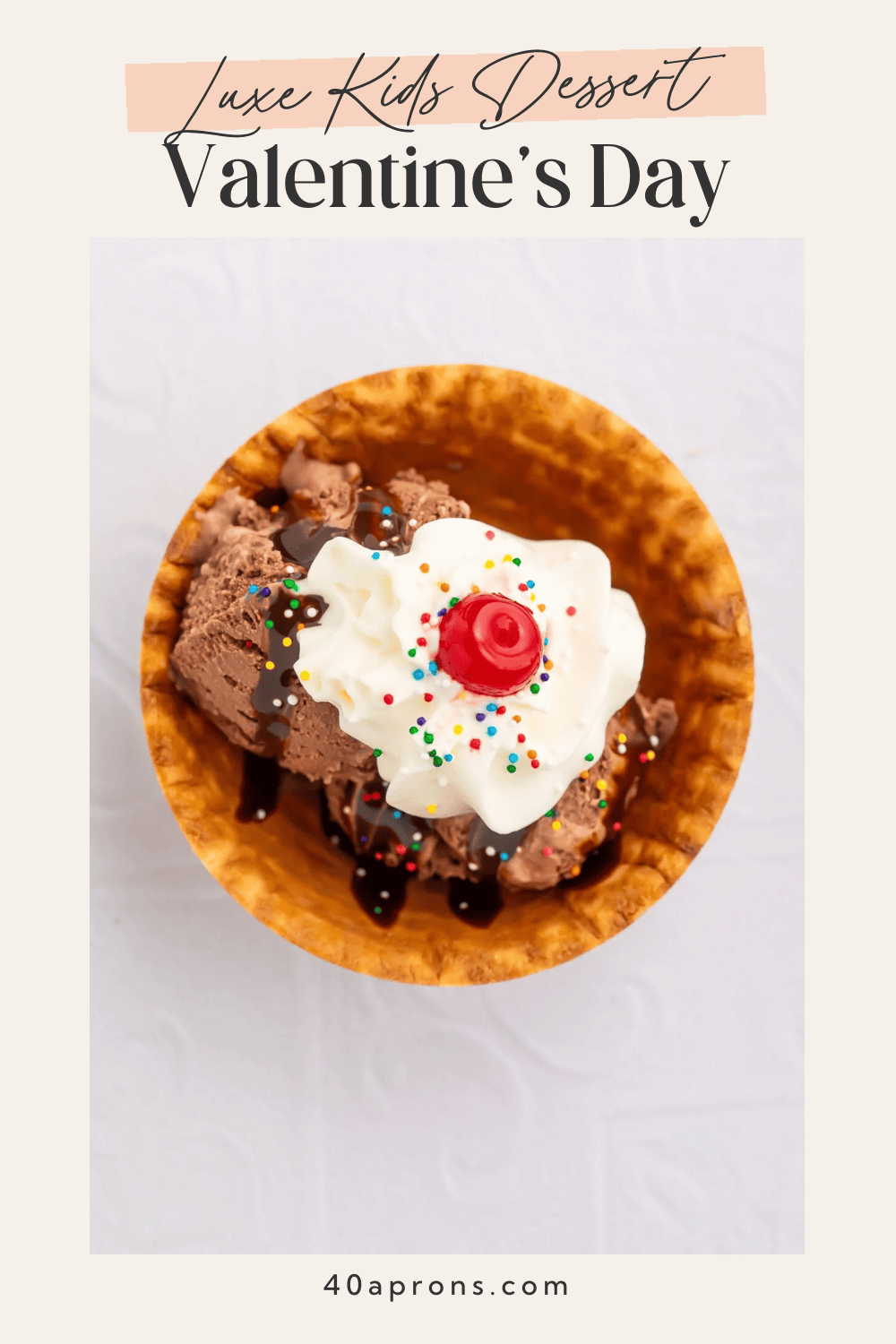 Pinterest pin for luxe kids Valentine's dessert showing chocolate ice cream sundae in waffle bowl with whipped cream, rainbow sprinkles, and cherry